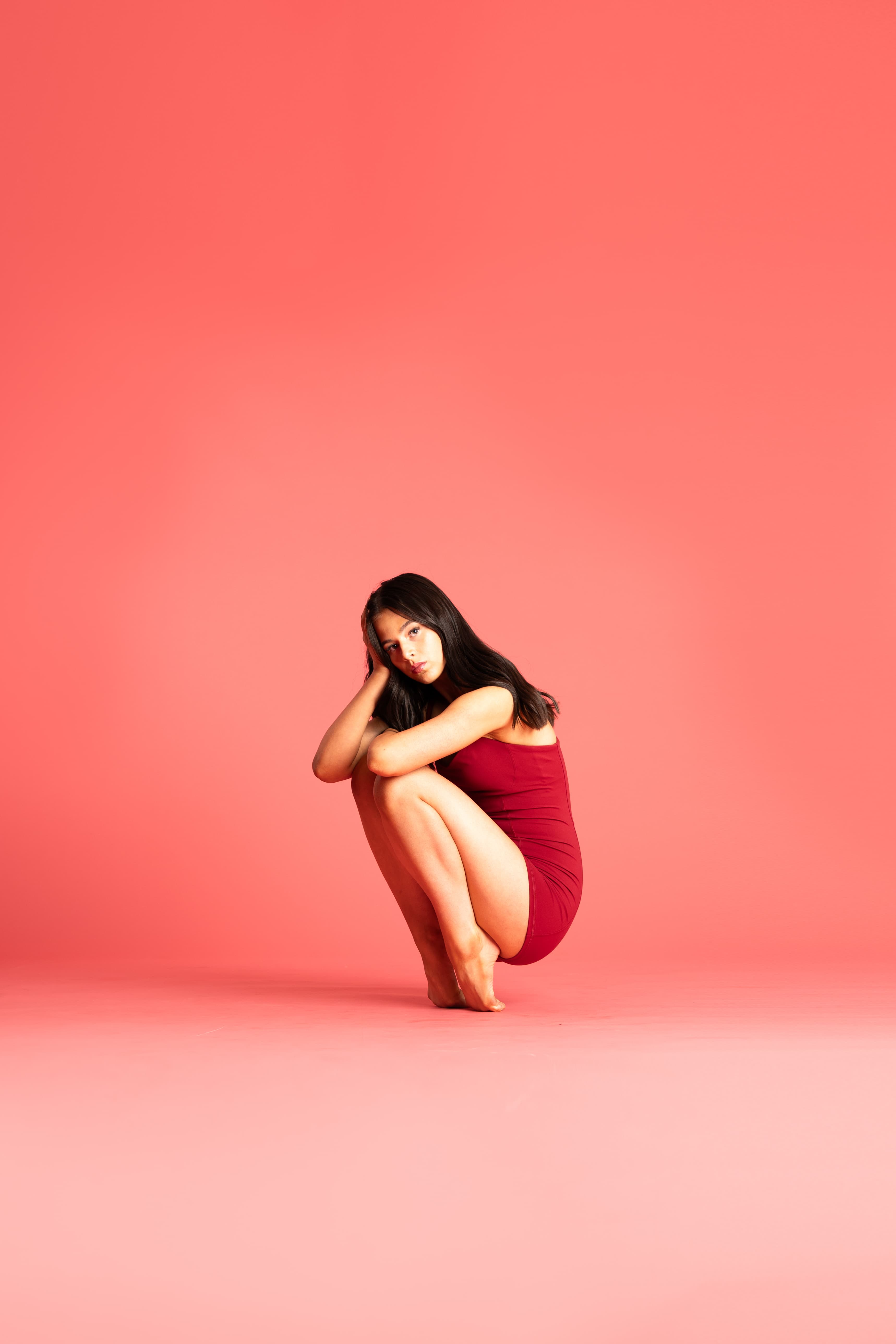 A Danceology dancer posed against a coral backdrop.